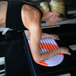 Mini tapis de sol pad de confort de la marque hercule studio modèle galé couleur axel rouge orangé mannequin sur un reformer de Pilates