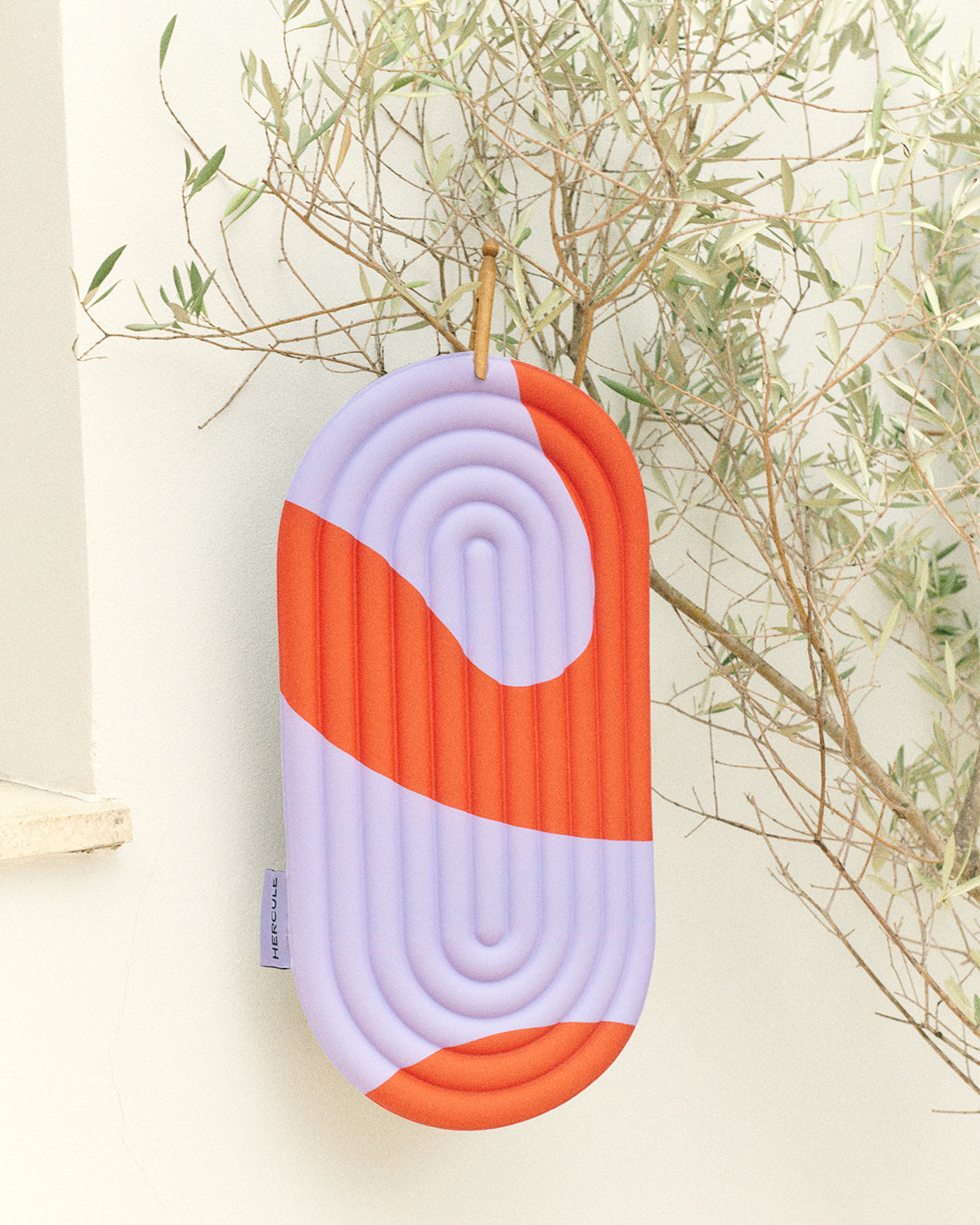 Mini tapis de sol pad de confort de la marque hercule studio modèle galé couleur axel rouge orangé produit accroché dans un olivier