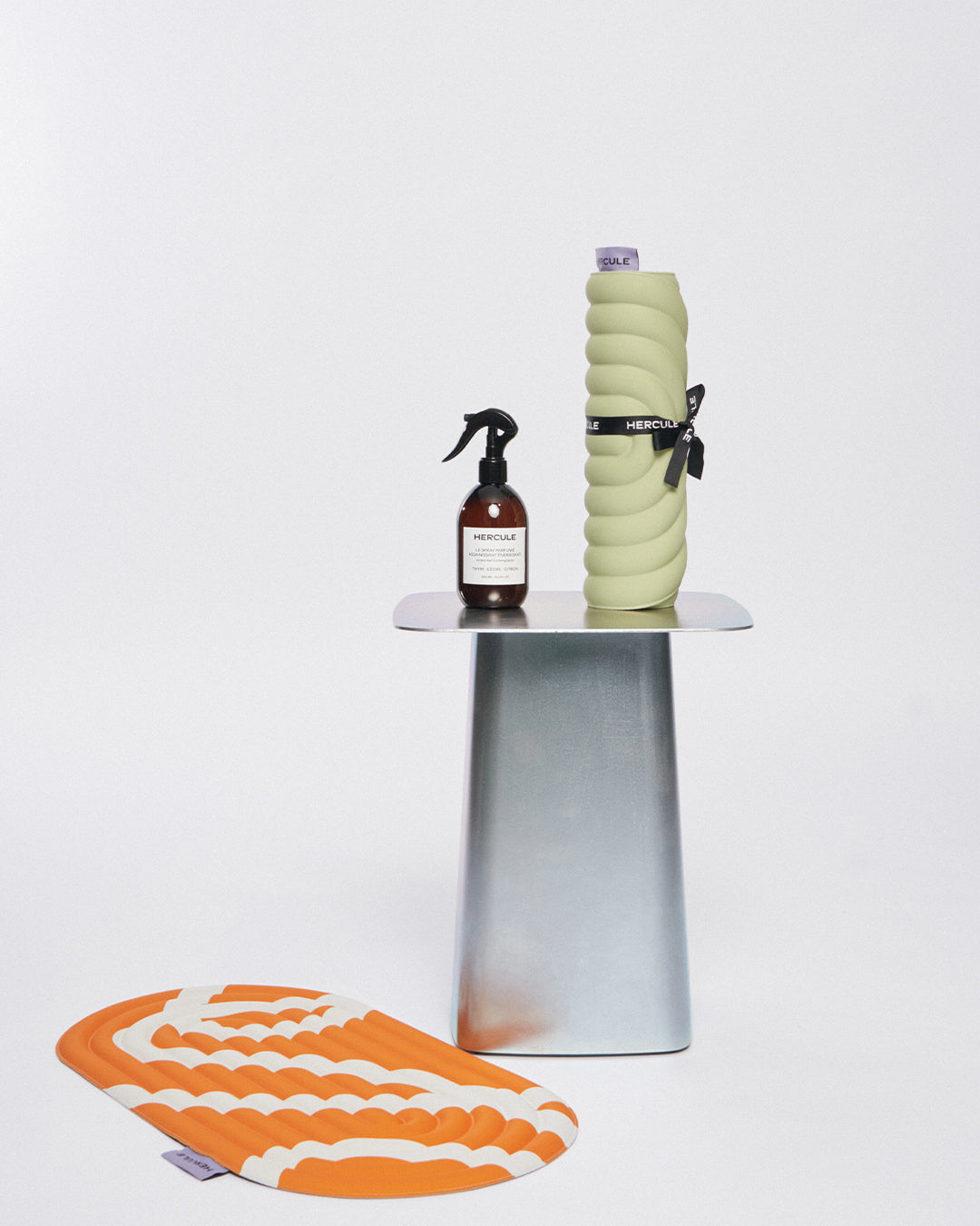 Mini tapis de sol pad de confort de la marque hercule studio modèle galé couleur pistache sur fond blanc avec spray et pad de confort bari orange pop