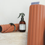 Set essentiel avec tapis de sport Archy, mini tapis de sport Galé couleur Terre cuite et spray parfumé de la marque Hercule Studio photo lifestyle avec marbre