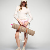 Tapis de sol pour le fitness le yoga et le pilates en cachemire de la marque hercule studio en collaboration édition limitée avec from future modèle archy couleur beige photo lifestyle avec mannequin et sangle de transport soca