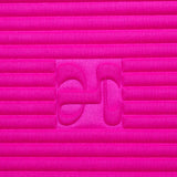 Close-up on the fuchsia pink cashmere texture and embossed H logo of the Hercule Studio x From Future Candy Pink sport mat