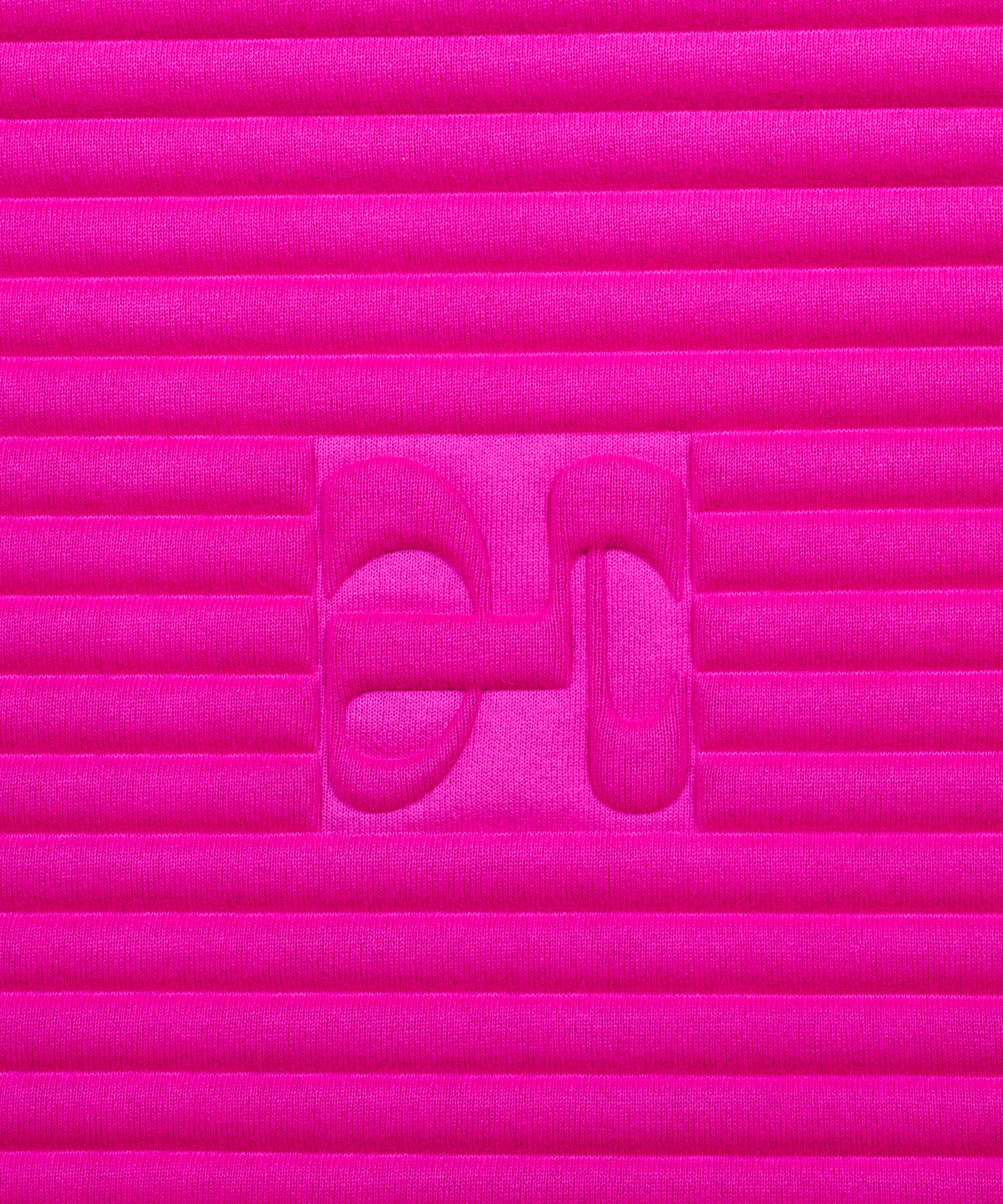 Close-up on the fuchsia pink cashmere texture and embossed H logo of the Hercule Studio x From Future Candy Pink sport mat