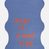 Close-up of the quote “Now is a good time” on the Hercule Studio x Thomas Lélu yoga mat, featuring an inspiring red message on a blue background